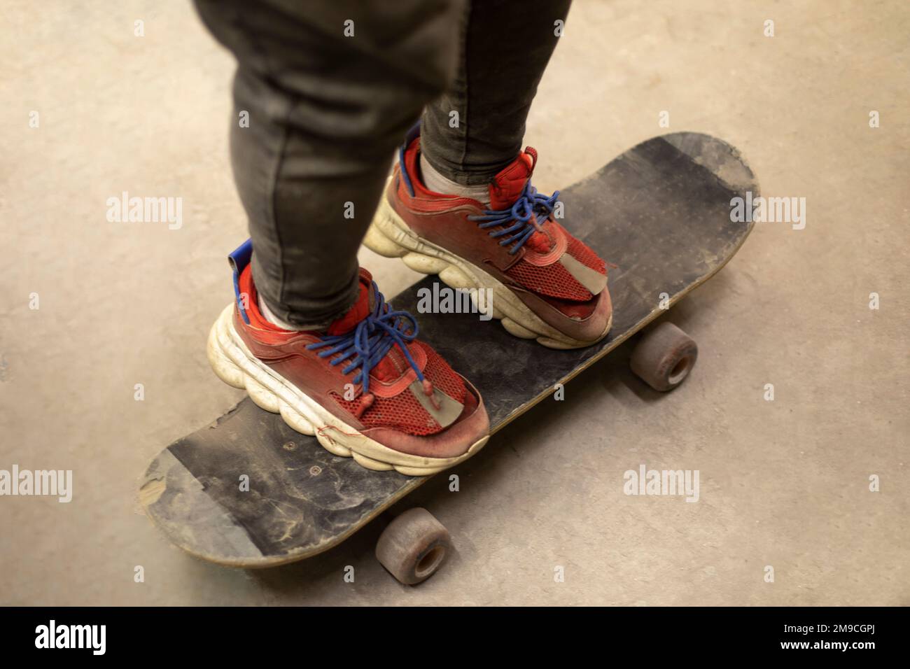 Ragazzo sullo skateboard. Trucco a bordo. Sneaker rosse. Sport estremi. Foto Stock