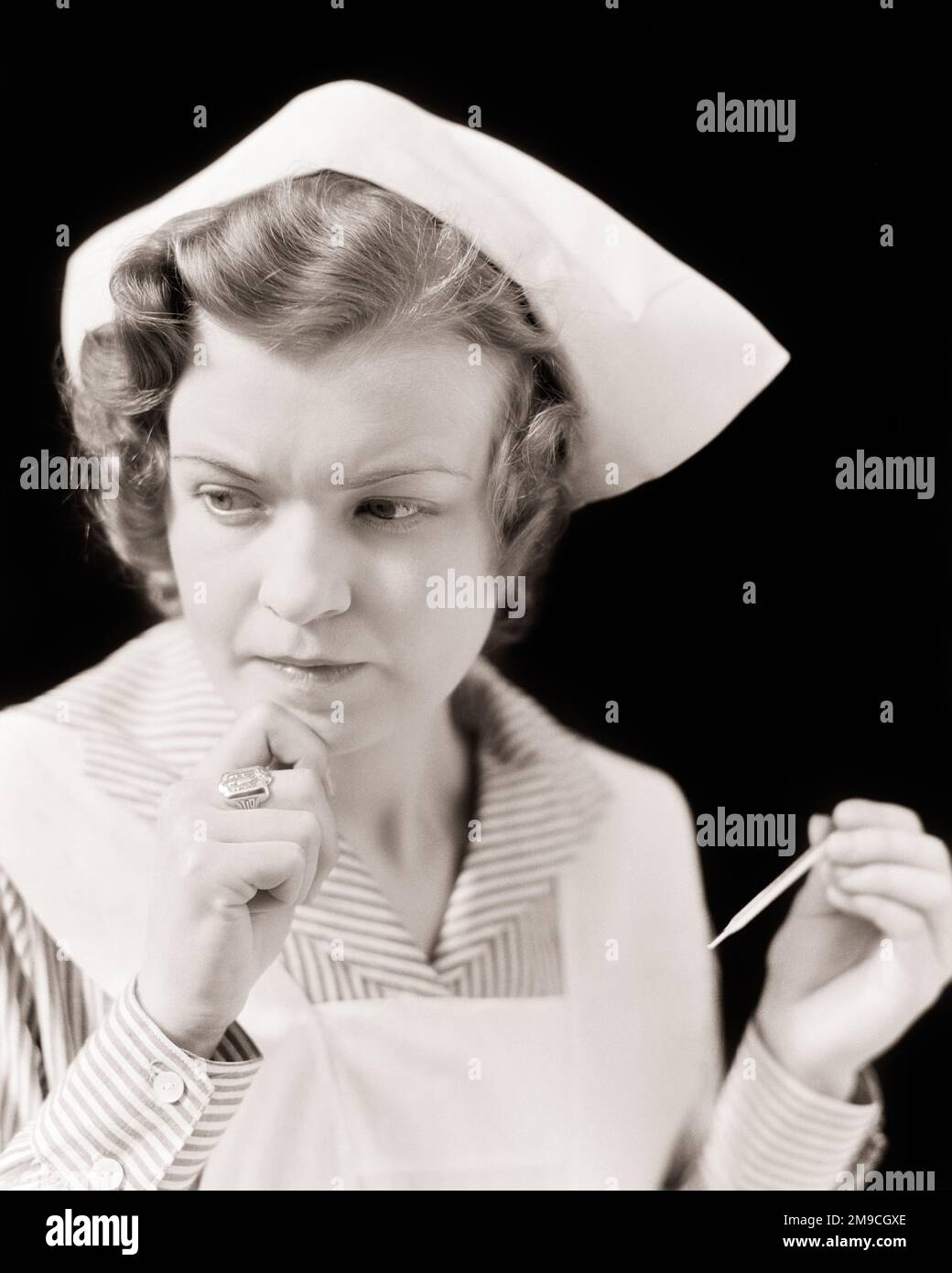1930S PREOCCUPATA DONNA INFERMIERA CONTROLLO PER LA FEBBRE TENERE UN VECCHIO MODO MASSIMO MERCURIO-IN-VETRO SCUOTERE PER REIMPOSTARE IL TERMOMETRO MEDICO - N1007 HAR001 HARS SHAKE FEMMINE TERMOMETRO POSTI DI LAVORO STUDIO SHOT COPIA SPAZIO SIGNORE PERSONE CURA RISCHIO PROFESSIONE ESPRESSIONI B&W INTERESSATI TRISTEZZA SANITÀ ABILITÀ DI OCCUPAZIONE DI TEMPERATURA ABILITÀ TESTA E SPALLE FORNITORE DI FEBBRE FORNITORI DI SCOPERTA MEDICI CURANTI CARRIERE DI SALUTE DI ASSISTENZA SANITARIA UN CAPPED OCCUPAZIONI GUARITORE PROFESSIONISTA MASSIMO MEDIO-ADULTO MEDIO-ADULTO DONNA PROFESSIONISTI NERO E BIANCO CAUCASICO ETNIA HAR001 VECCHIO STILE Foto Stock