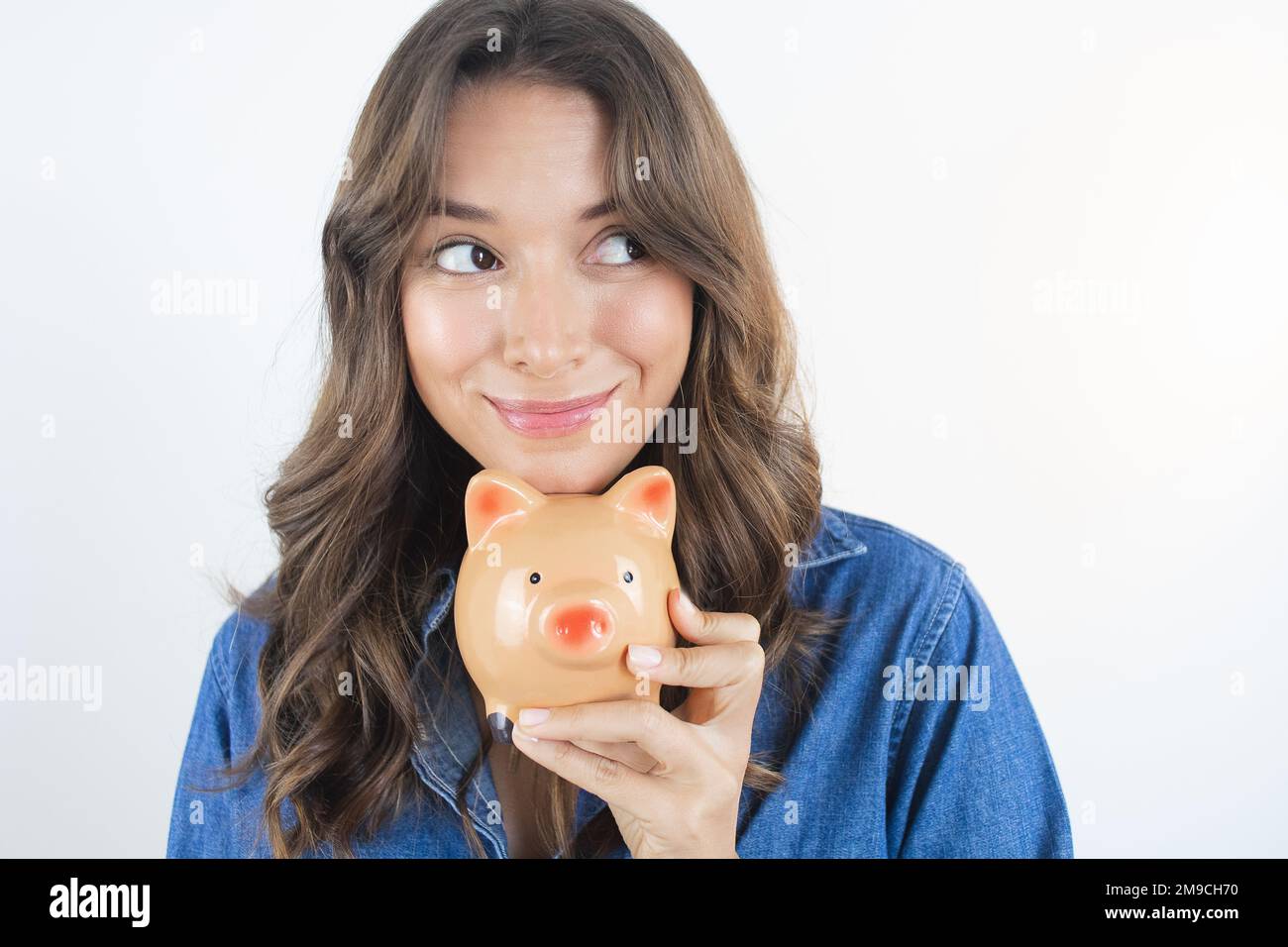 Donna felice che tiene un sogno di risparmio della banca del Piggy Foto Stock