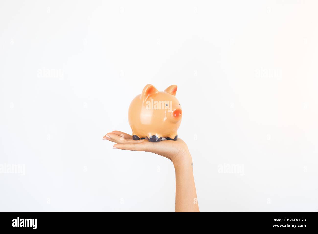 Mano di risparmio che tiene una Banca del Piggy Foto Stock