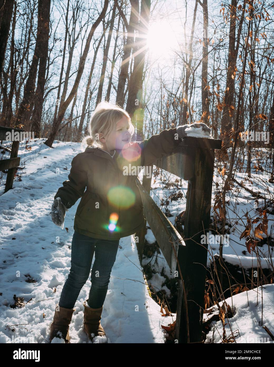 Bambino che gioca nella neve sul ponte durante l'escursione Foto Stock