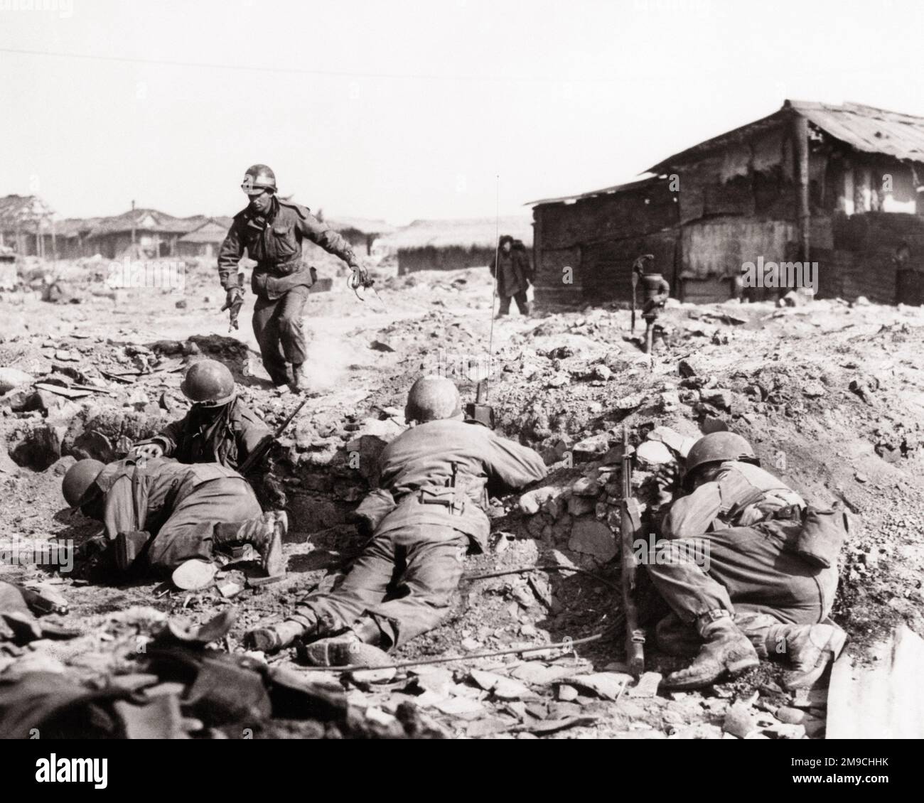 1950S 1951 UNITÀ DI FANTERIA DELL'ESERCITO AMERICANO PRENDE LA COPERTURA DAL FUOCO COMUNISTA CINESE DELLE PICCOLE ARMI AI MARGINI DEL VILLAGGIO COREANO COREA DEL SUD - Q987 CPC001 UNITÀ DI ECCITAZIONE DI HARS OCCUPAZIONI POLITICHE UNIFORMI 1951 SQUADRA CONCETTUALE COREANA GUERRA COREANA AZIONE DELLA POLIZIA COREANA PRENDE L'ARMISTIZIO FANTERIA COMUNISTA NERO E BIANCO VECCHIO STILE Foto Stock