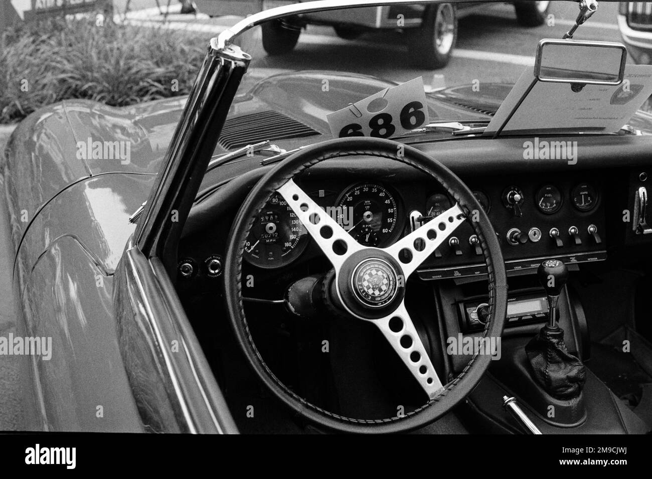 Il cruscotto di un'automobile convertibile Jaguar e-Type ad un'esposizione dell'automobile in Essex, Massachusetts. L'immagine è stata acquisita su pellicola analogica in bianco e nero. Foto Stock