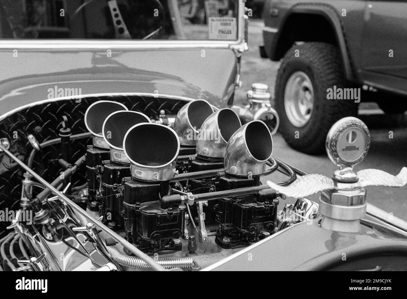 Il vano motore di una classica automobile Hot Rod ad una fiera di automobili in Essex, Massachusetts. L'immagine è stata acquisita su pellicola analogica in bianco e nero. Foto Stock
