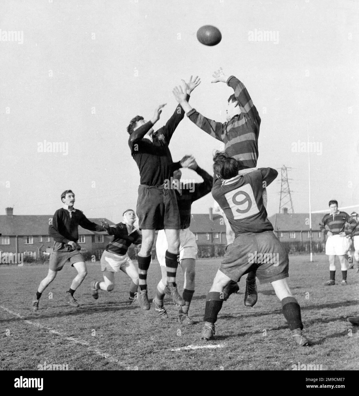 Saltando per la palla durante una vivace partita di rugby a scuola a Staines, Middlesex, Inghilterra. Foto Stock