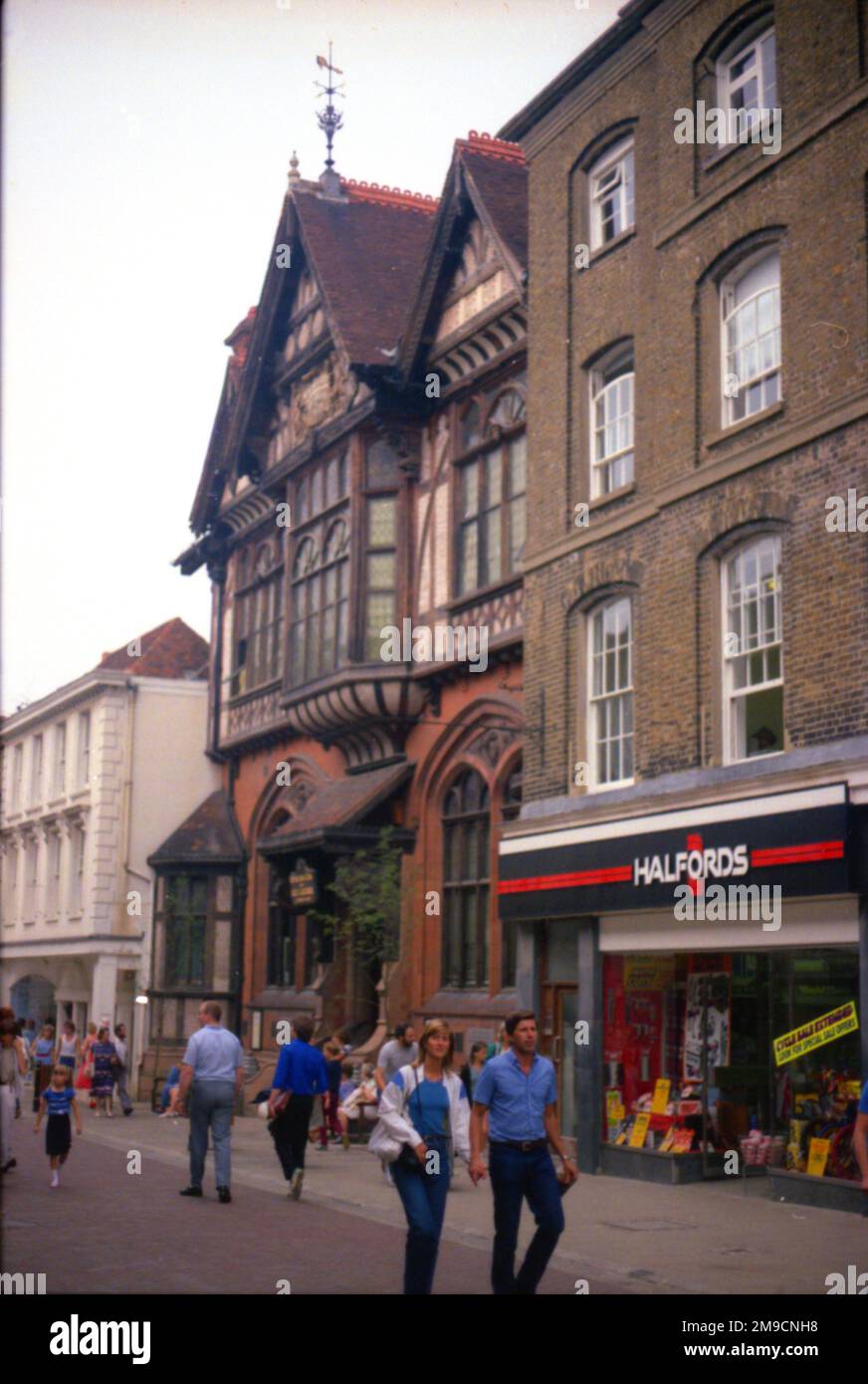 Gli amanti dello shopping camminano lungo la strada tra i negozi di Canterbury, Kent Foto Stock