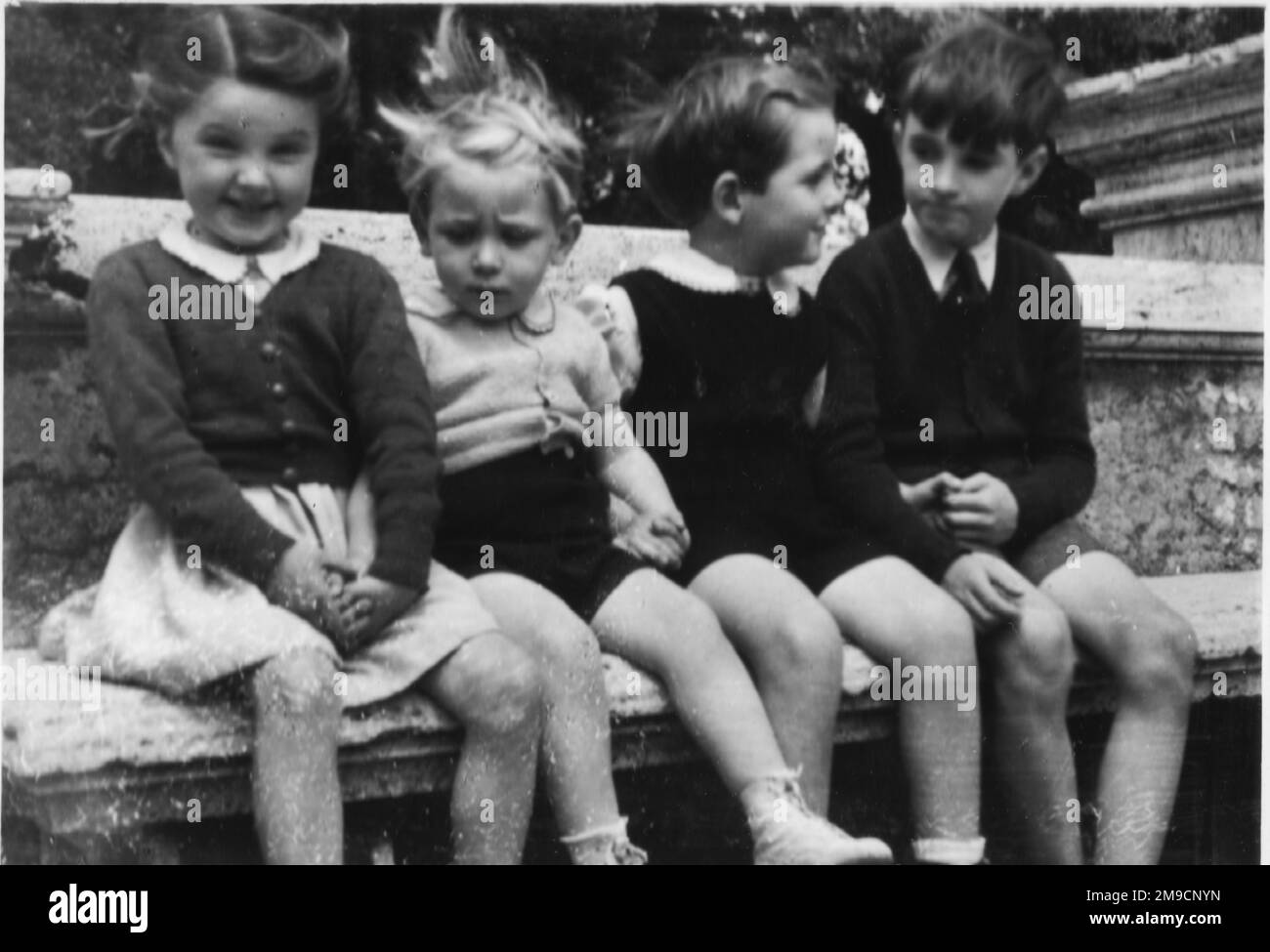 Quattro bambini italiani seduti in fila. Foto Stock