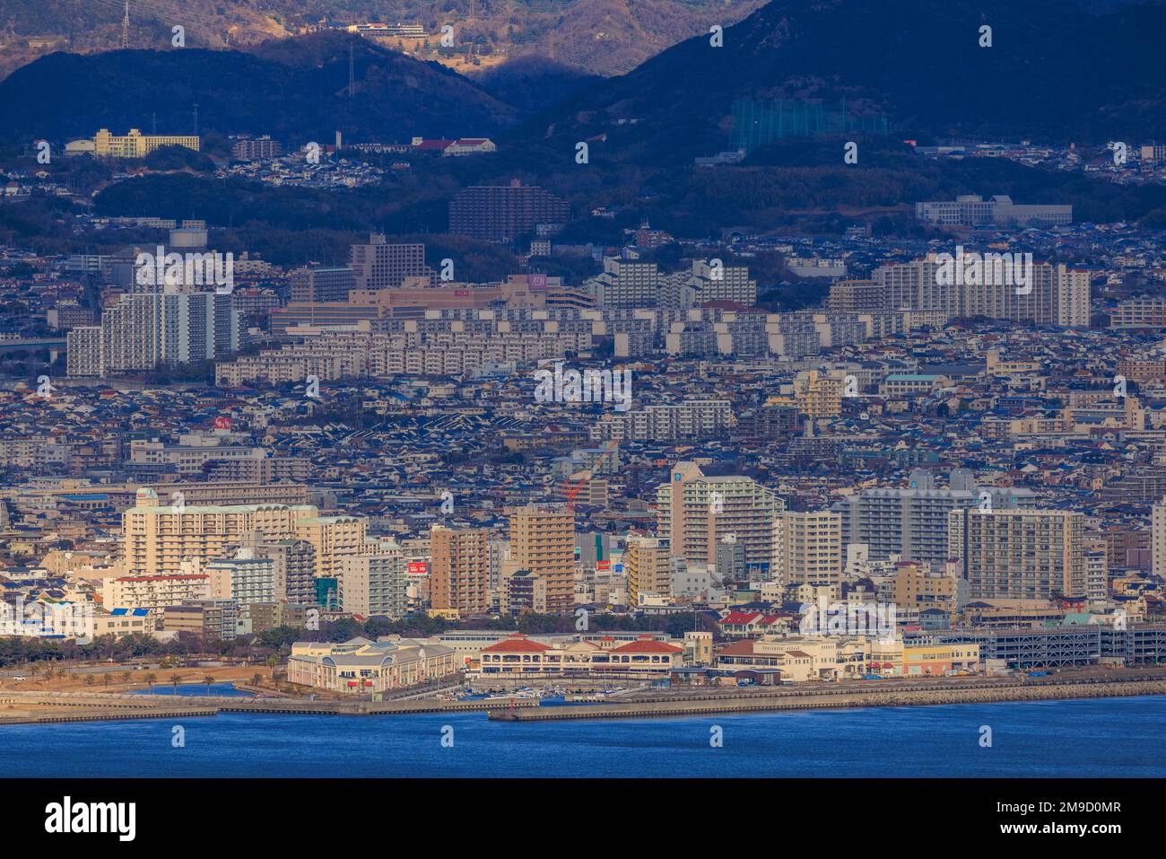 Tarumi, Giappone - 16 gennaio 2023: Appartamenti residenziali a più piani in una vasta città collinare sulla costa Foto Stock