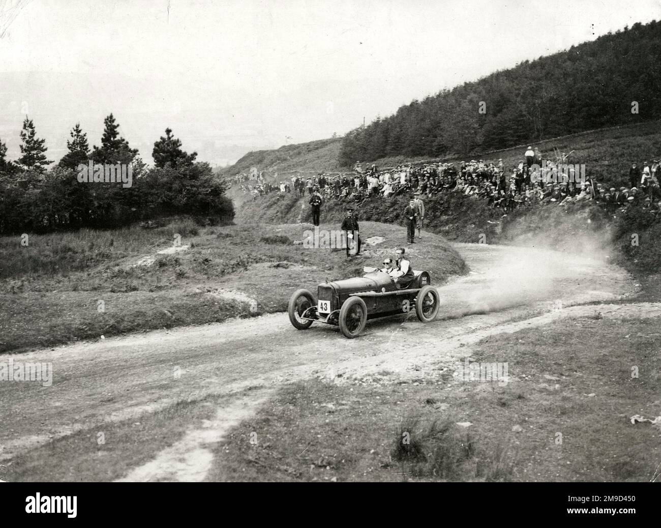 Malcolm Campbell e Villa in Auto 43 con Union Jack in dietro con la folla e 2 poliziotti in salita sparso Eagle Hill, Shaftesbury. Foto Stock