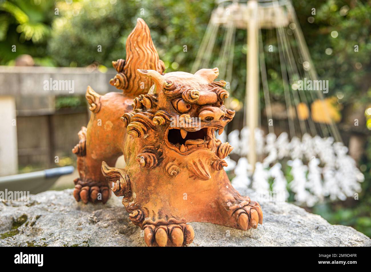 Documenti di preghiera a bocca aperta per shisa e omikuji al Ryukyu Mura di Okinawa, Giappone Foto Stock