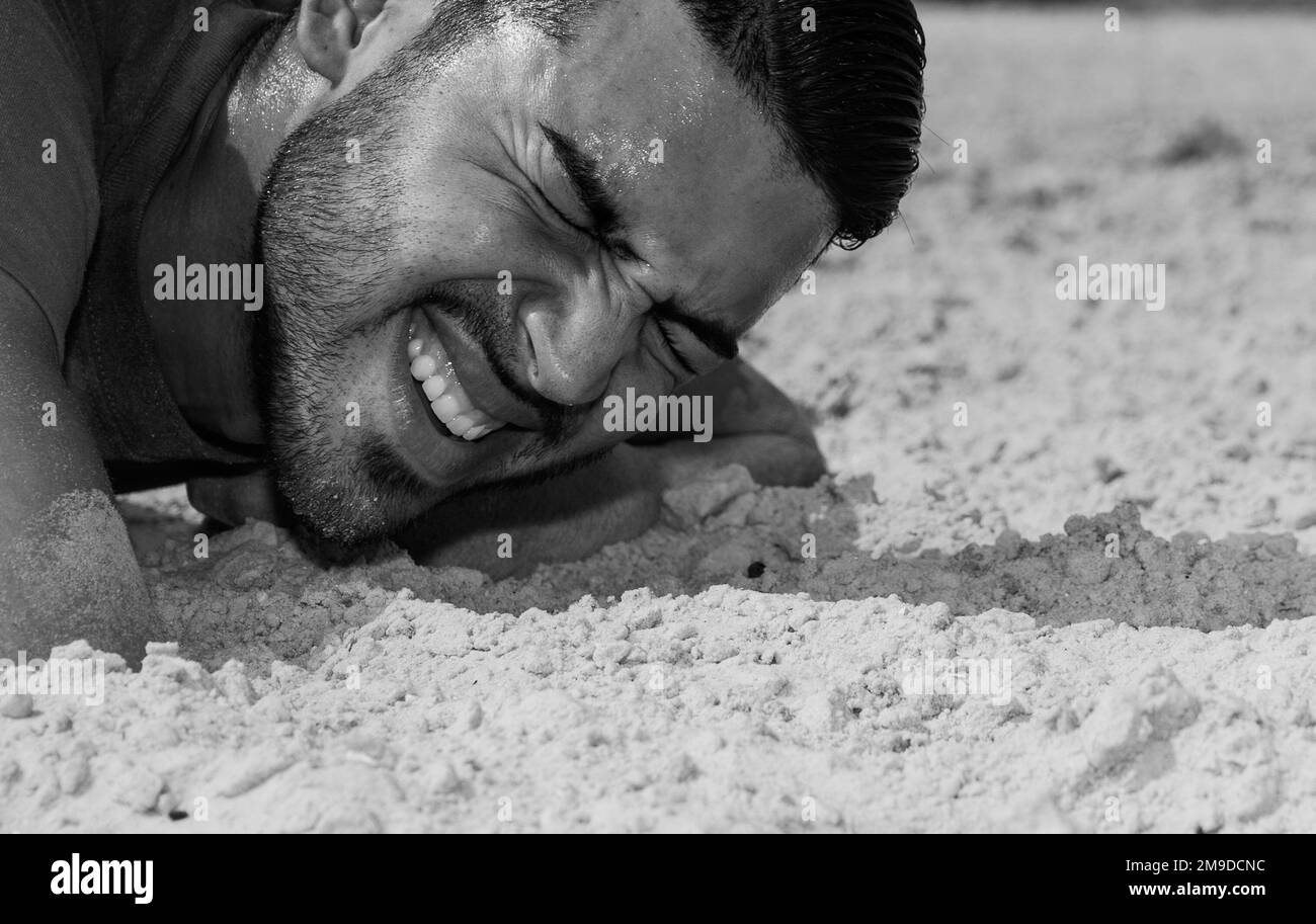 STATI UNITI L'Airman Bryan Cardona-Badillo, un difensore assegnato allo Squadrone delle forze di sicurezza del 6th, striscia sulla sabbia durante la seconda sfida annuale dei difensori del 17 maggio 2022, a MacDill Beach, Florida. La sfida consisteva in un complessivo fucile M-4 carbine ripiegato alla cieca, una marcia di fucile e un giro in spiaggia. Ogni anno, i MacDill Airmen si riuniscono per celebrare la settimana nazionale della polizia onorando le forze dell'ordine militari e civili che hanno pagato il sacrificio finale mentre erano in linea di dovere. Foto Stock