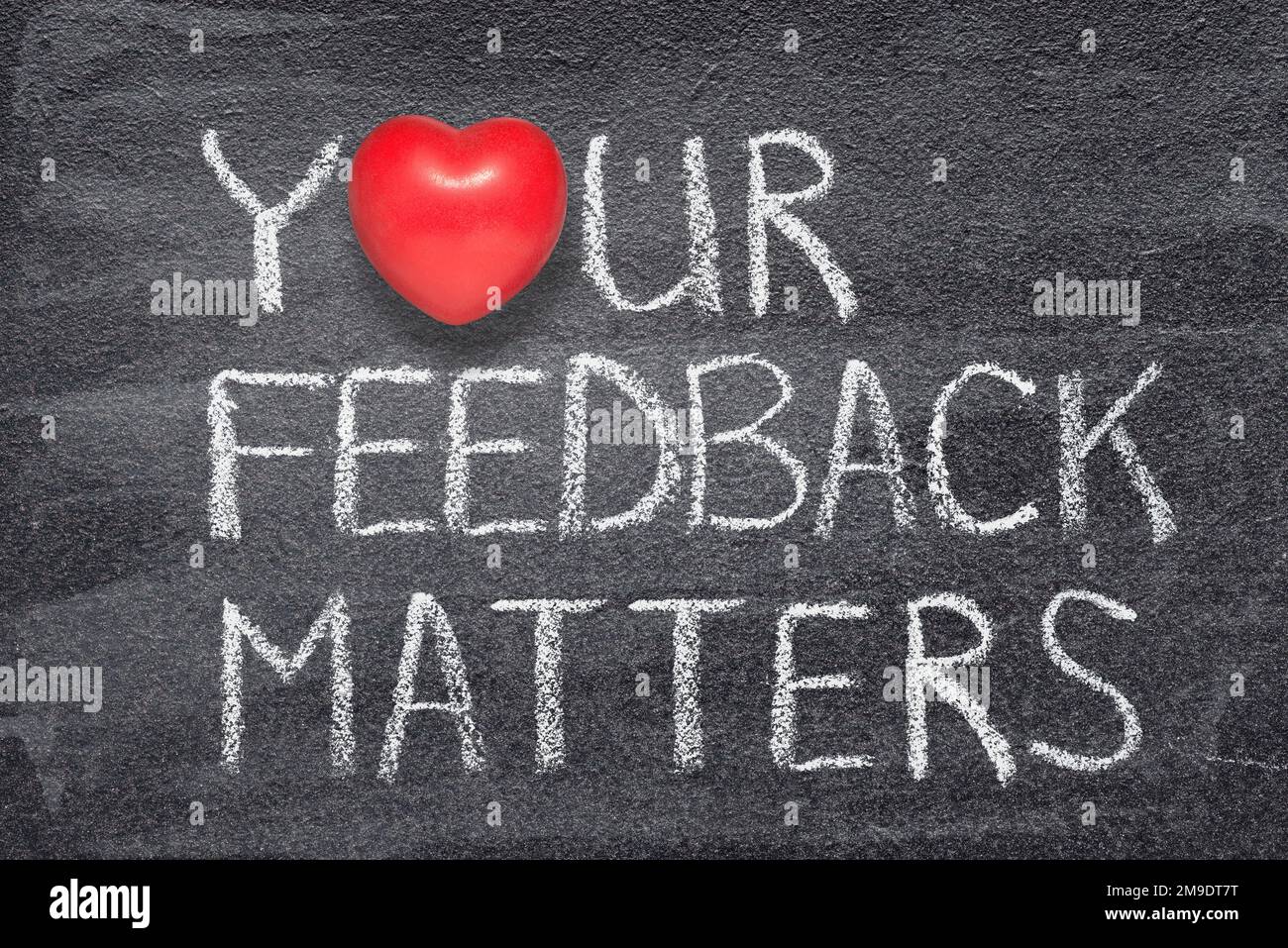 il tuo feedback è importante per la frase scritta sulla lavagna con il simbolo del cuore rosso Foto Stock
