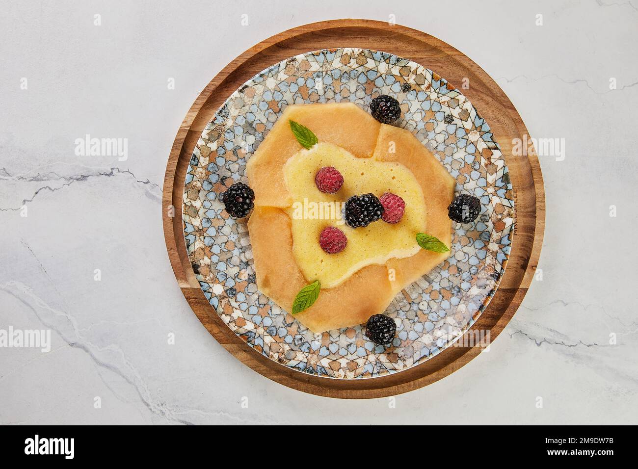 Carpaccio di melone con lamponi freschi e mirtilli a bordo. Foto Stock