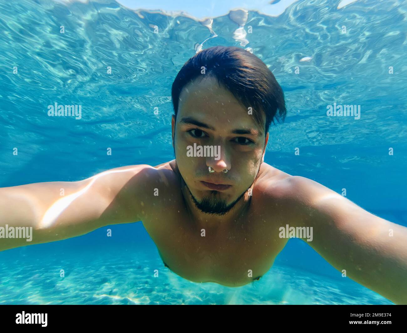 giovane subacqueo maschile nuota in mare e prende un selfie in vacanza in estate Foto Stock