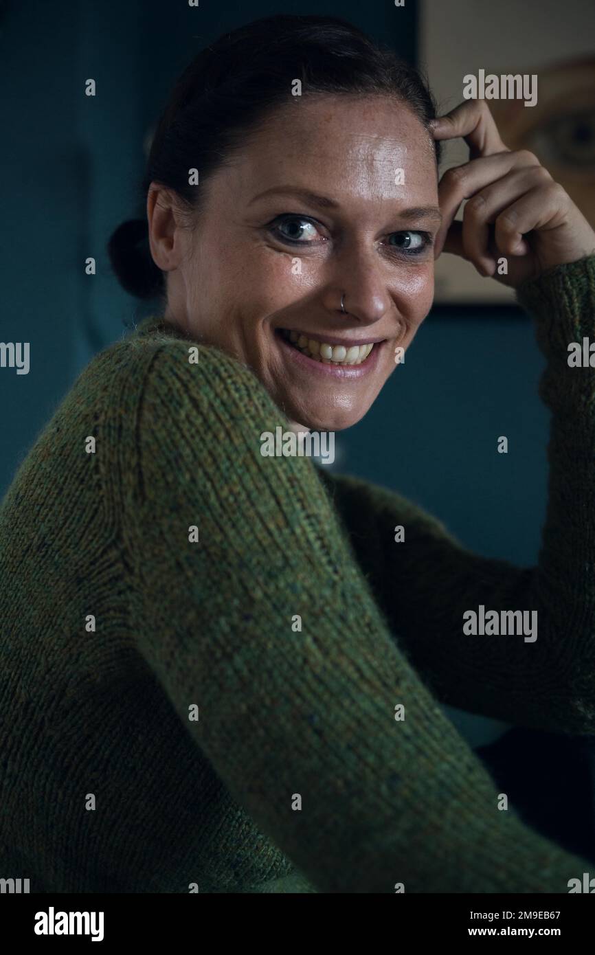Donna felice, interno girato di una donna in un maglione di lana lavorato a maglia, ritratto Foto Stock