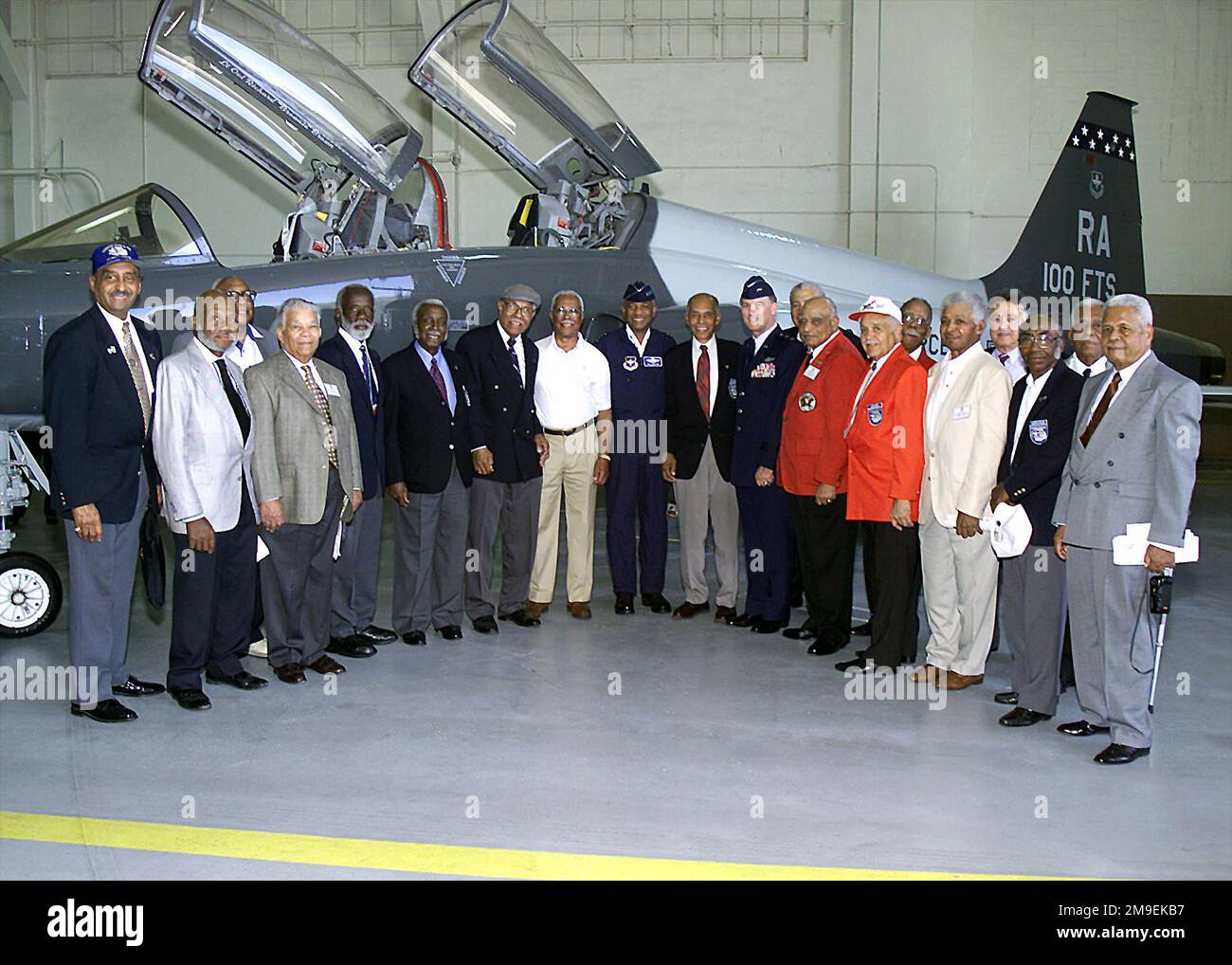 Interno Hangar, scatto medio lungo, vista frontale, General Lloyd W. 'Fig' Newton, USAF, Commander, Air Education and Training Command, Randolph Air Force base, Texas, (al centro) stand con 16 aerei Tuskegee del 100th Fighter Squadron, 340th personale del gruppo di formazione volante e un generale maggiore USAF non identificato di fronte a un Talon T-38C. Il 100th FS era una delle quattro unità completamente nere originariamente assegnate alla base aerea dell'esercito di Tuskegee, Alabama. Gli squadroni della seconda guerra mondiale non hanno mai perso un bombardiere sotto la loro scorta ai combattenti nemici. Due unità Tuskegee il 99th e 100th FSS è stato riattivato come il 99th e. Foto Stock