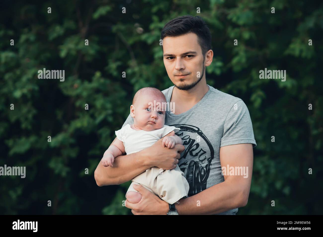 giovane papà felice con un bambino neonato in mano alla natura in estate Foto Stock