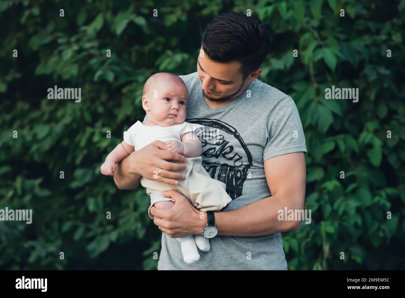giovane papà felice con un bambino neonato in mano alla natura in estate Foto Stock