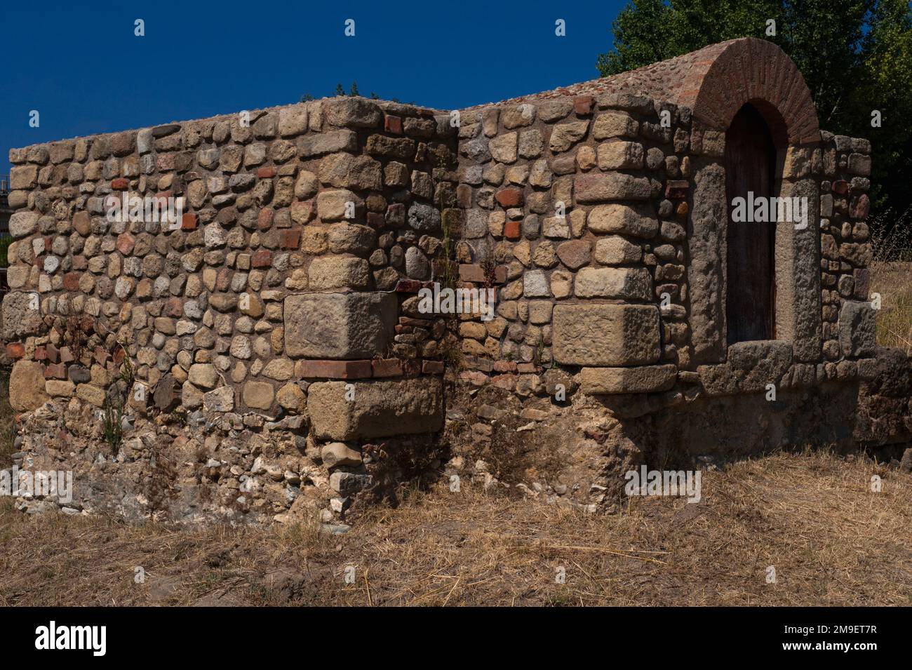 Grande passo in su: Soglia di porta ad arco tondo in edificio restaurato con tetto a tunnel tra resti scavati dell'antico porto greco-romano di Velia è ora ben al di sopra del livello del suolo. L'edificio sorge, con le sue fondamenta esposte, nel quartiere meridionale del Parco Archeologico di Elea Velia a Marina di Ascea, sulla costa del Mar Tirreno in Campania. Foto Stock