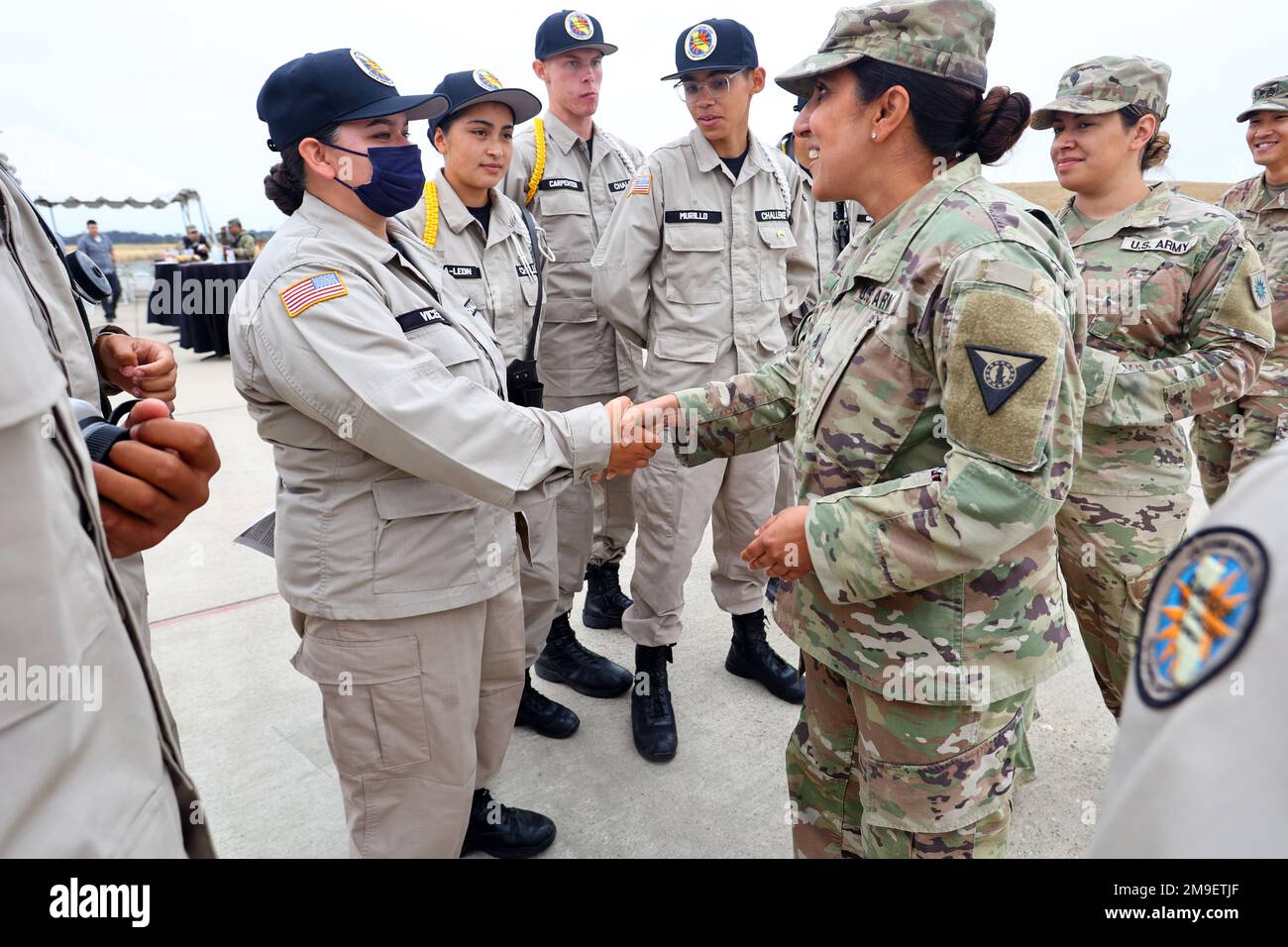 STATI UNITI Manju Vig, comandante della base di addestramento delle forze congiunte, Los Alamitos, Coins Sunburst Youth Challenge Academy Classe 29 Cadet Angel Vicente e altri cadetti che hanno presentato i colori durante una cerimonia rivoluzionaria, il 19 maggio 2022, Per un progetto di resilienza energetica presso la base di addestramento delle forze congiunte a Los Alamitos, California. Sunburst Youth Challenge Academy si trova sull'installazione e i cadetti spesso supportano gli eventi sulla base. Foto Stock