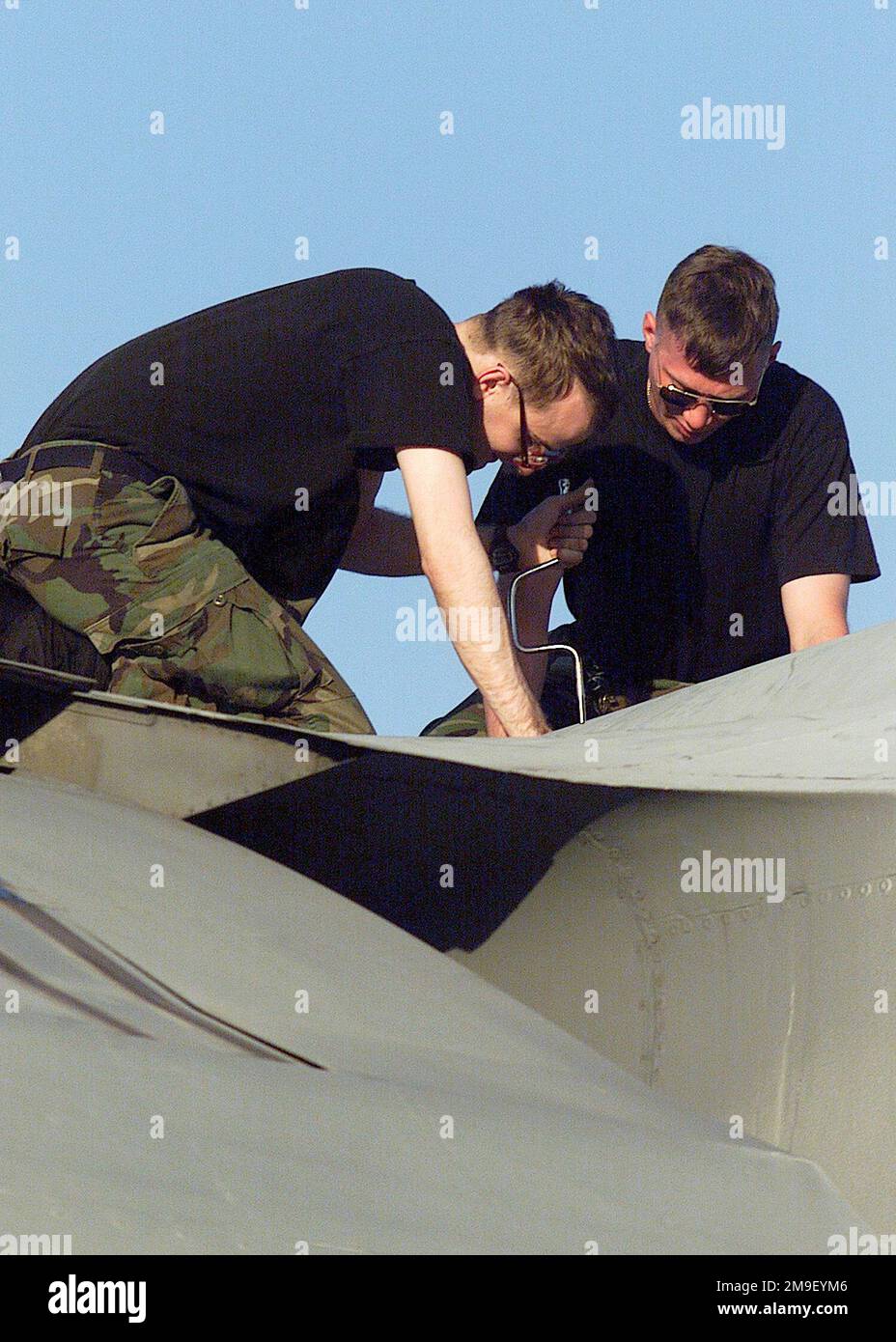 Scatto medio, angolo basso, SENIOR Airmen Brian Martin e Richard Carlton, USAF Crew Chiefs, 305th Aircraft Generation Squadron, McGuire Air Force base, New Jersey, cambiare la luce di formazione alare su uno Starlifter C-141b. Prefecero l'aereo prima del decollo per una missione alle truppe airdrop della 82nd Airborne Division, Fort Bragg, North Carolina, nella zona di caduta della Sicilia a Fort Bragg, North Carolina. L'esercizio, chiamato Large Package Week, prevede l'atterraggio aereo di 1200 paracadutisti dall'Airborne 82nd e delle loro attrezzature pesanti nella zona di caduta. Large Package Week è un quarto Foto Stock