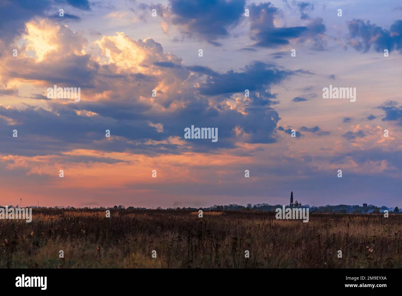 Paesaggio con la Chiesa Ortodossa all'orizzonte nella sera d'autunno con un bel cielo Foto Stock