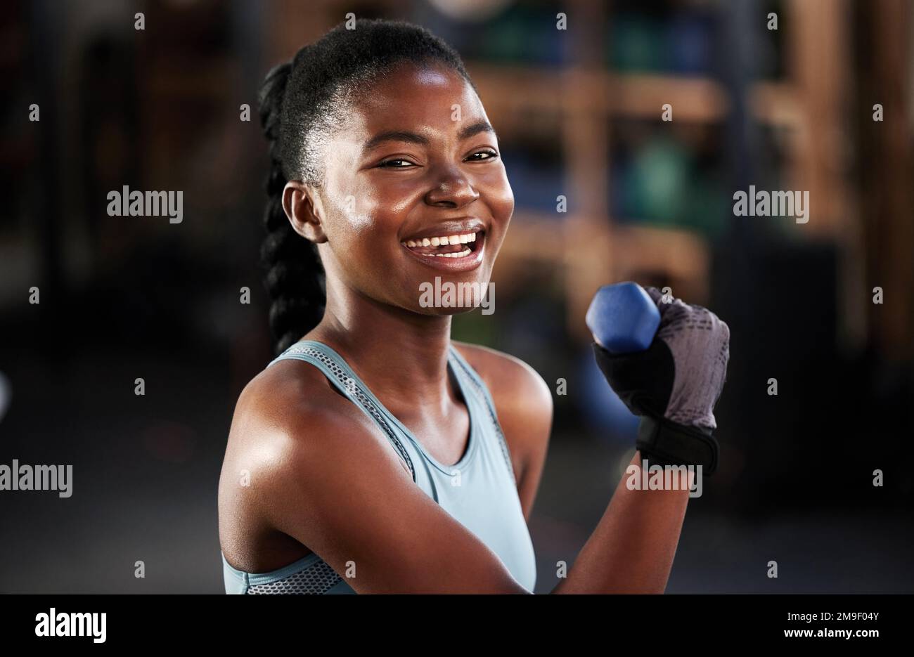 Occhi puntati sul premio. una giovane donna in forma che si allenava con i manubri in palestra. Foto Stock