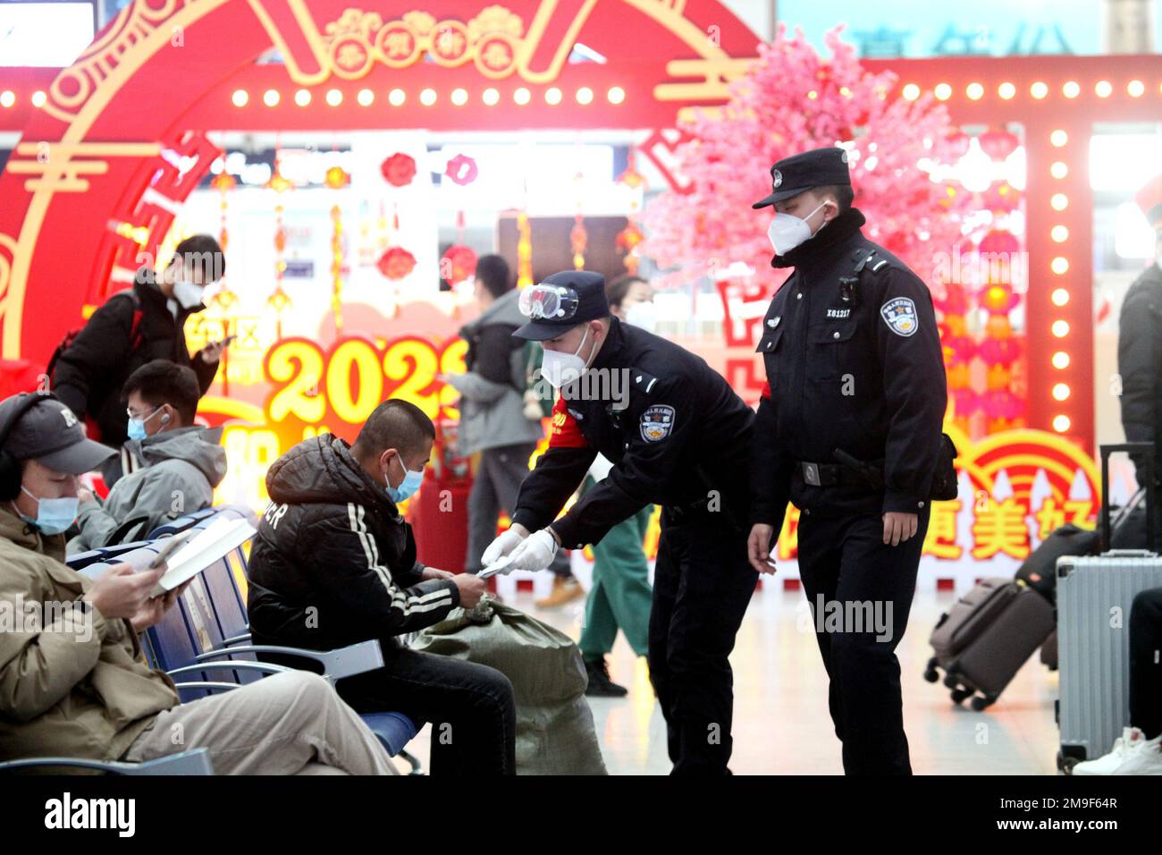 SHENYANG, CINA - 18 GENNAIO 2023 - gli agenti di polizia servono i passeggeri nella sala d'attesa di una stazione ferroviaria di Shenyang, provincia di Liaoning, Cina, Foto Stock