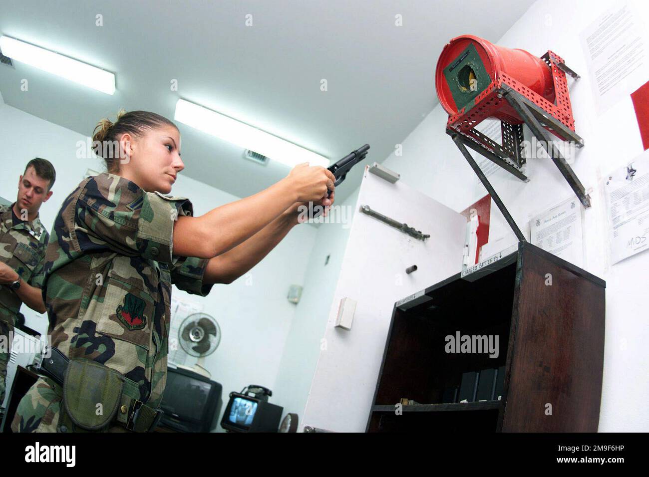 Profilo destro medio primo piano da un angolo basso guardando in alto come US Air Force AIRMAN First Class Ryann Cecci, 731st Munizioni supporto Squadron, è il primo Armorer. Controlla M-16s, M-9s e le radio per il rilascio alle forze di sicurezza durante il montaggio della guardia presso la base aerea di Araxos, Grecia. Base: Araxos Air base Paese: Grecia (GRC) Foto Stock