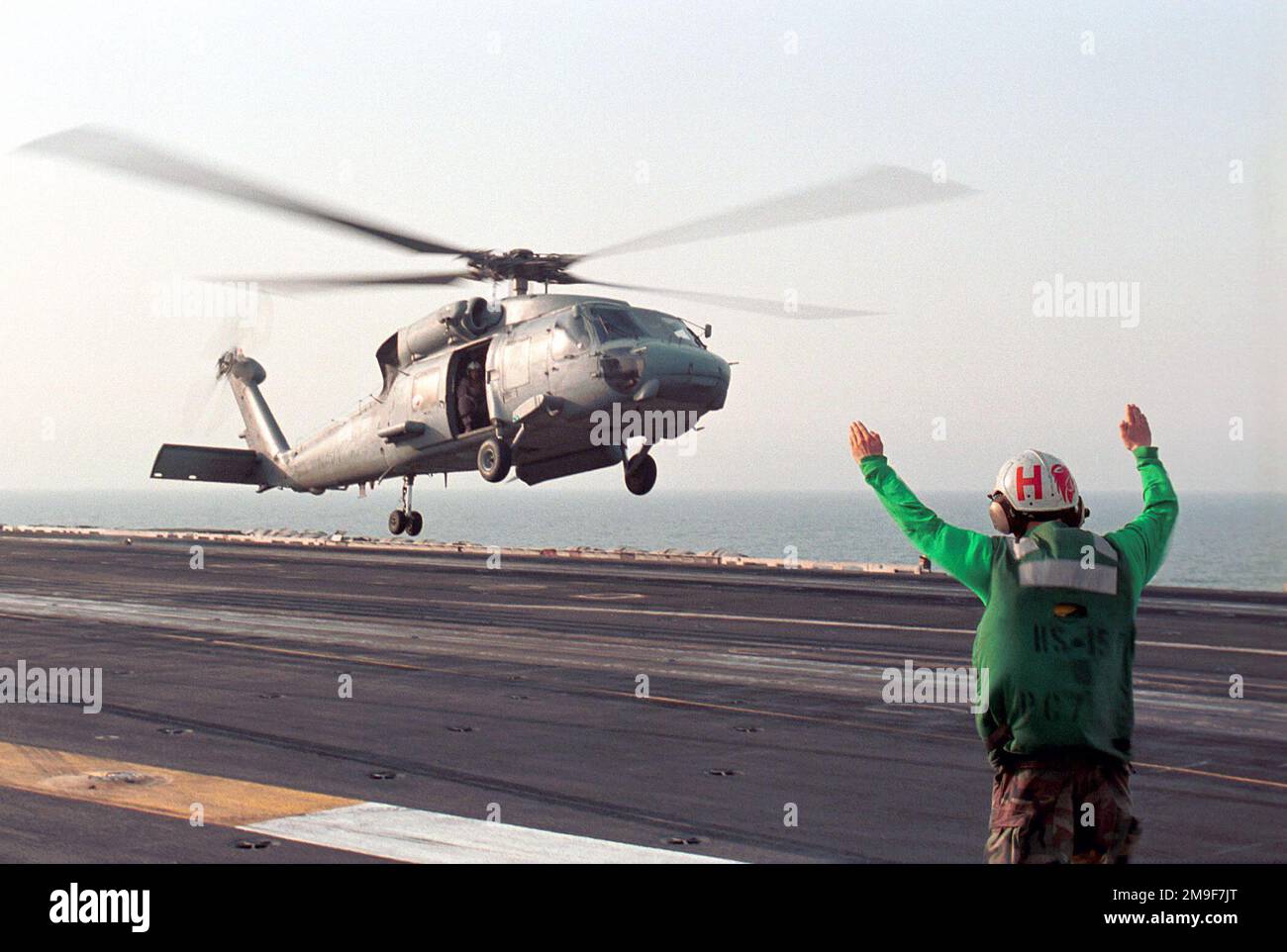 L'Aviation Electronics Technician 3rd Class Brian Hurst dà il segnale per un elicottero SH-60 'Seahawk' attaccato ai 'Red Lions' dell'elicottero Anti-Submarine Squadron One Five (HS-15) da lanciare dal ponte di volo della USS George Washington (CVN 73). WASHINGTON opera nel Golfo Arabico a sostegno dell'operazione SOUTHERN WATCH (OSW). L'OSW è la missione che impone la coalizione imposta a sud "no-fly zone” sull'Iraq. Soggetto operativo/Serie: SOUTHERN WATCH base: USS George Washington (CVN 73) Foto Stock