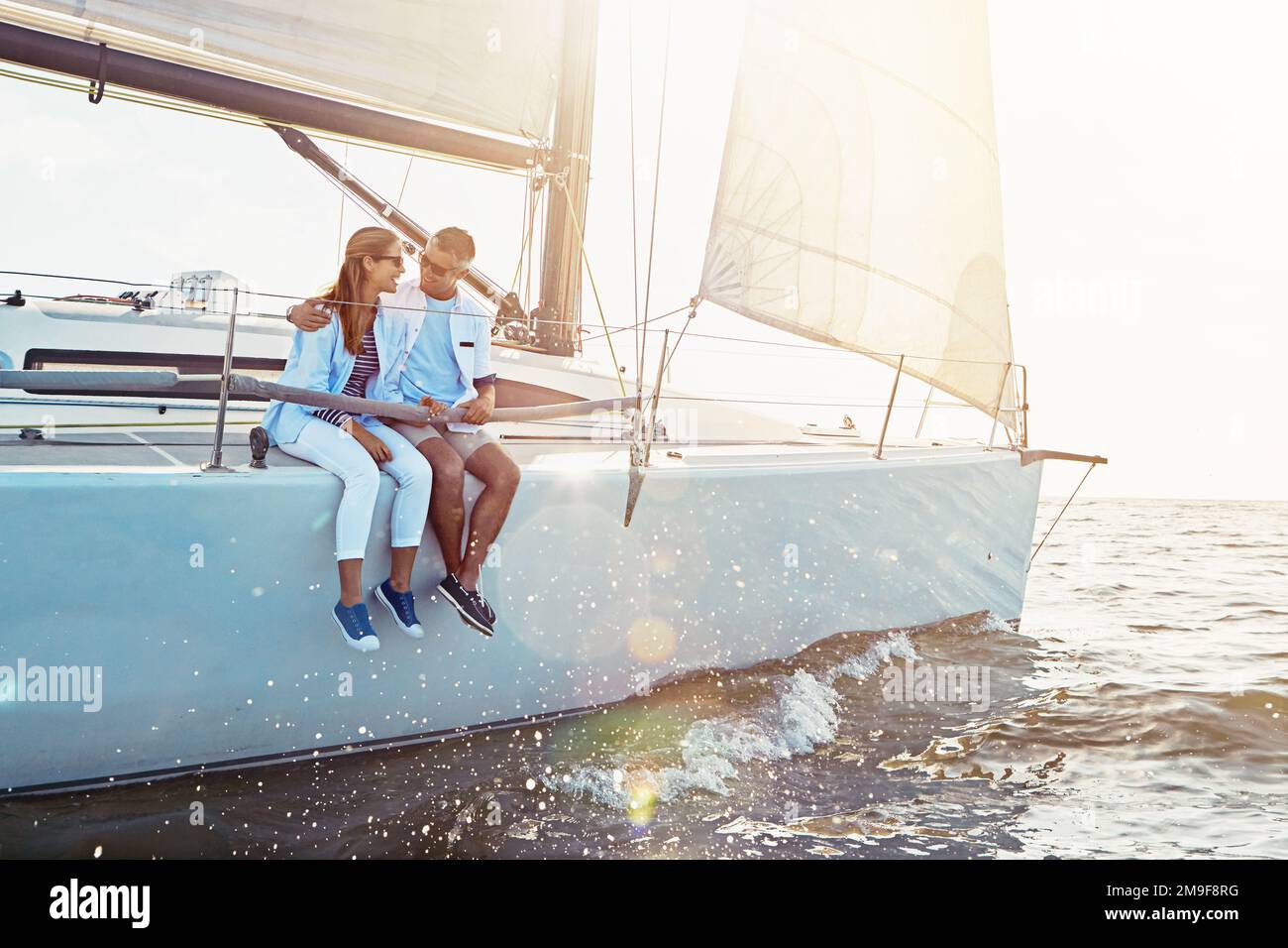 Coppia felice, nave e crociera per abbracciare, oceano o sole estivo per amore, romanticismo o avventura all'aperto. Uomo, yacht e donna con onde, legame o. Foto Stock