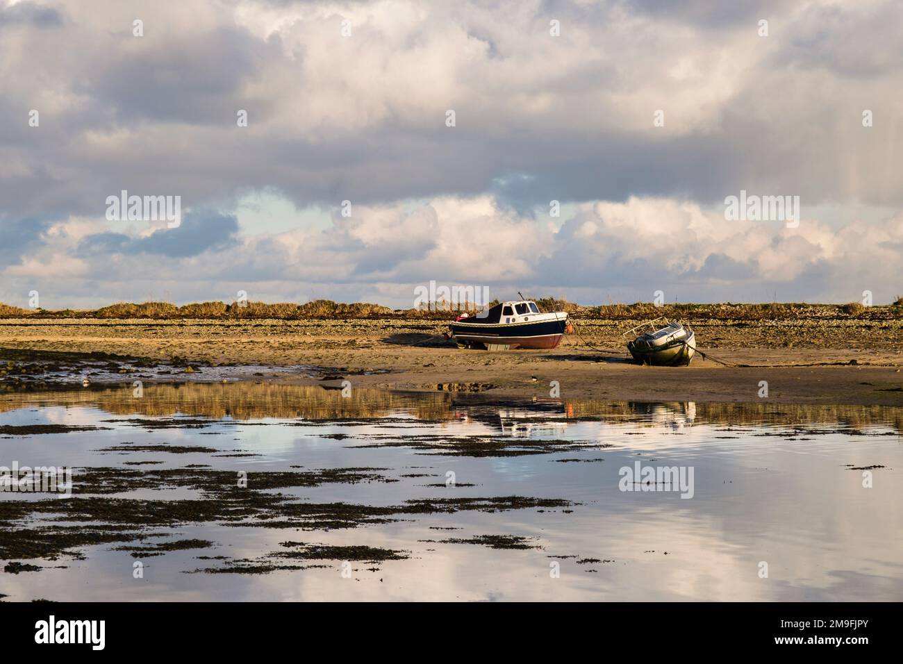 Barche a terra su banco di sabbia con marea in arrivo nel porto a Red Wharf Bay (Traeth Coch), Isola di Anglesey (Ynys Mon), Galles, Regno Unito, Gran Bretagna, Europa Foto Stock