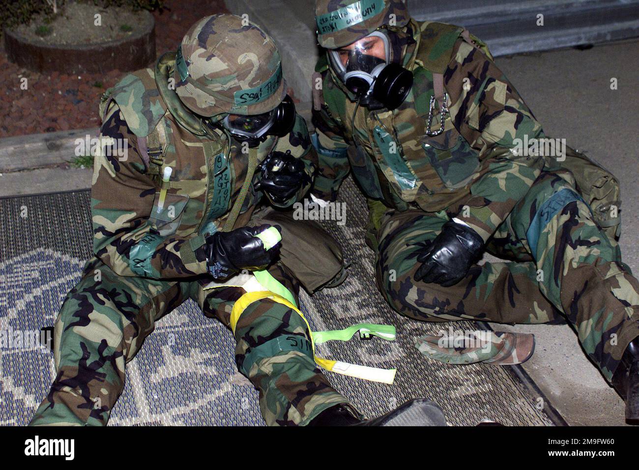 IL SERGENTE dell'AERONAUTICA DEGLI STATI UNITI Alfonso Prater (a sinistra) e l'ANZIANO DELL'aeronautica degli Stati Uniti Alexis Johnson, 51st membri dello squadrone di trasporto (TRNS), si aiutano a vicenda con il primo soccorso dopo che sono stati feriti dallo shrapnel da un colpo simulato dello SCUD sul composto di trasporto alla base aerea di Osan, Repubblica di Corea. L'evento si è svolto durante l'ispezione operativa di preparazione (ORI) del 2001 presso Osan AB, Repubblica di Corea. (Immagine duplicata, vedere anche DF-SD-02-01412 o ricerca 010315-F-2095R-005). Base: Osan Air base Nazione: Repubblica di Corea (KOR) Foto Stock
