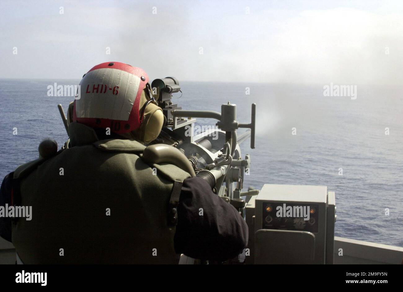 GUNNER's Mate 2nd Class Randy Thomas spara via dal cannone 25mm sulla USS BONHOMME RICHARD (LHD6) durante l'esercizio DEL KERNEL BLITZ 2001. KERNEL BLITZ è un esercizio di atterraggio anfibio su larga scala che si svolge nelle vicinanze di Camp Pendleton, California. Circa 25 navi, 75 aeromobili e 15.000 marinai, marinai, saldatori, aviatori e guardacoste in rappresentanza di quattro nazioni partecipano all'esercizio. Oggetto operativo/Serie: KERNEL BLITZ 2001 base: USS Bonhomme Richard (LHD 6) Stato: California (CA) Paese: Stati Uniti d'America (USA) Foto Stock