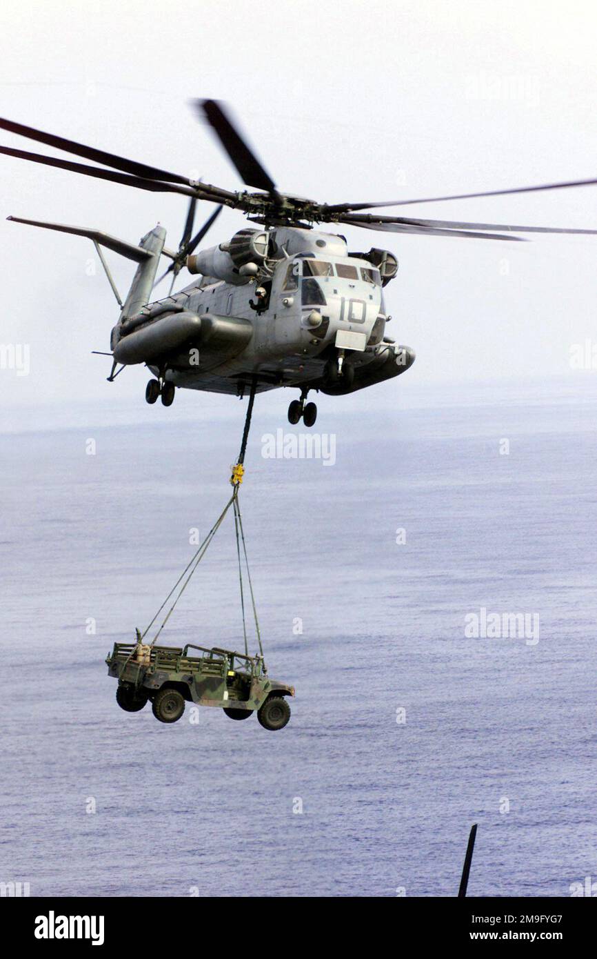 Un elicottero US Marine Corps (USMC) CH-53E Super Stallion utilizza un'imbracatura per sollevare un veicolo a ruote multiuso ad alta mobilità (HMMWV) dal ponte di volo della USS PELELIU (LHA 5), durante l'esercizio DEL KERNEL BLITZ 2001. Esercizio/Serie: KERNEL BLITZ 2001 base: USS Peleliu (LHA 5) Foto Stock