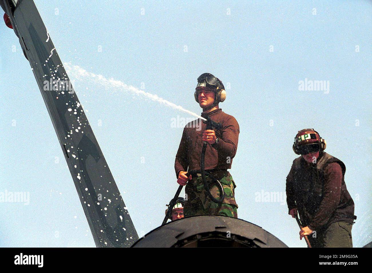 US Navy AIRMAN Apprentice Mike Mullen lava le suds fuori dell'ala di un F/A-18 Hornet Aircraft da Strike Fighter Squadron One Zero Five (VFA-105) sul ponte di volo di USS HARRY S. TRUMAN (CVN 75). Base: USS Harry S. Truman (CVN 75) Foto Stock