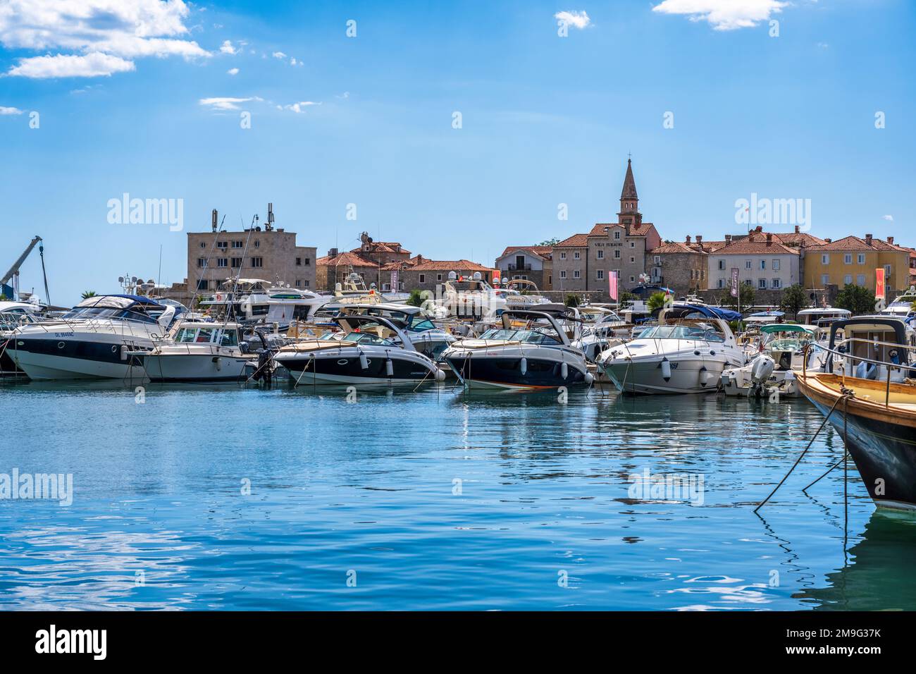 Barche a Dukley Marina, con la città vecchia (Stari Grad) sullo sfondo, a Budva, sulla costa adriatica del Montenegro Foto Stock