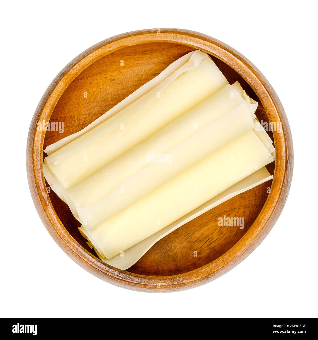 Involtini di formaggio duro svizzero, in una ciotola di legno. Tre fette sottili di Sbrinz, formaggio pieno extra duro, prodotto nella Svizzera centrale. Foto Stock