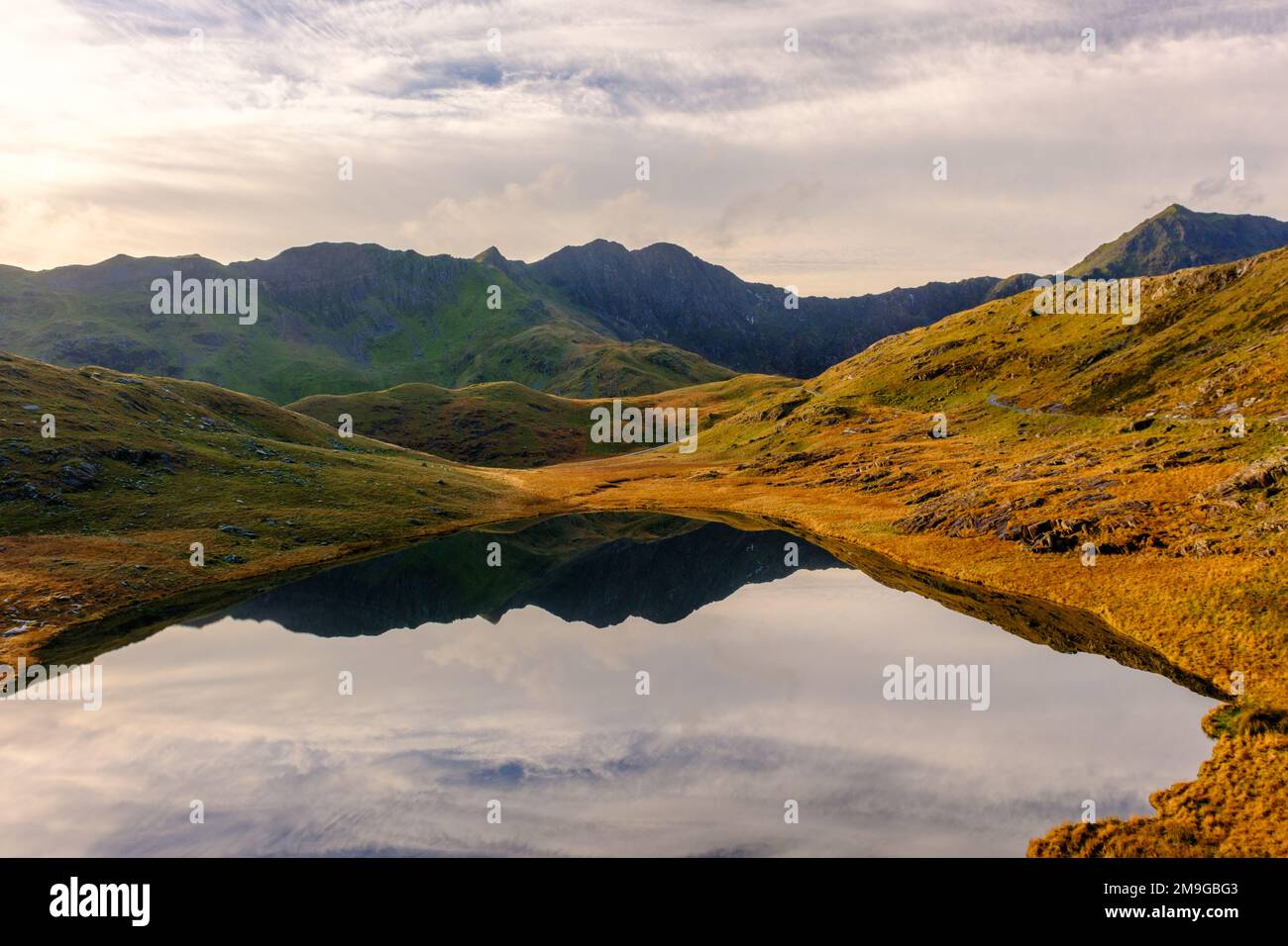 La cima di Snowdon si rifletteva in un lago nel Parco Nazionale di Snowdonia, Galles del Nord Foto Stock