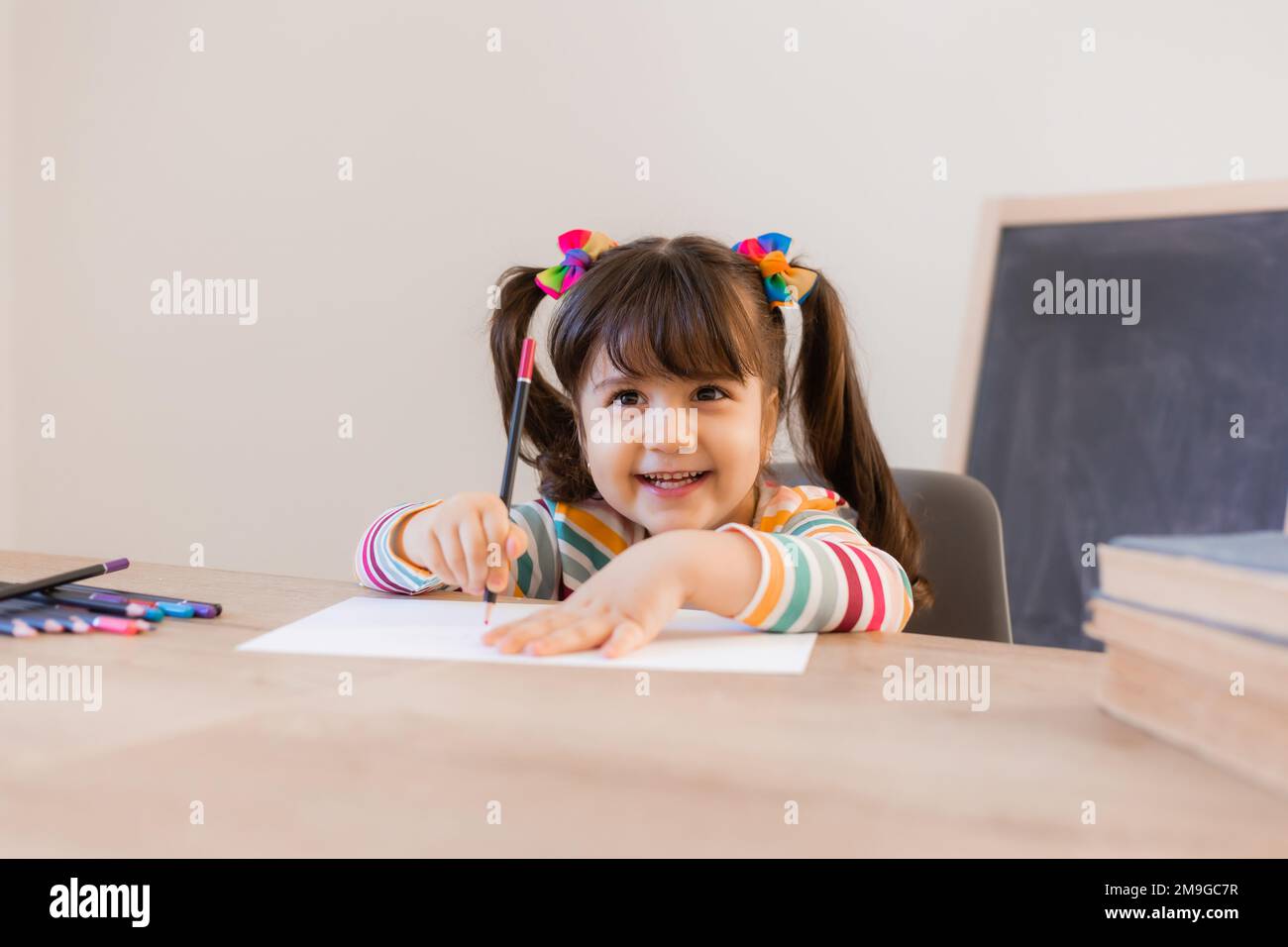 cute piccola ragazza disegna con matite colorate Foto Stock