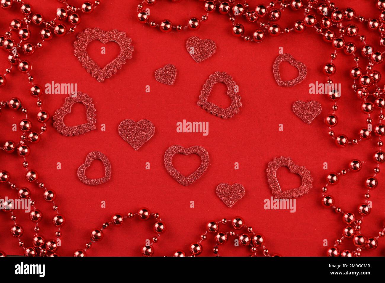 cuori rossi su sfondo rosso con spazio per il testo Foto Stock