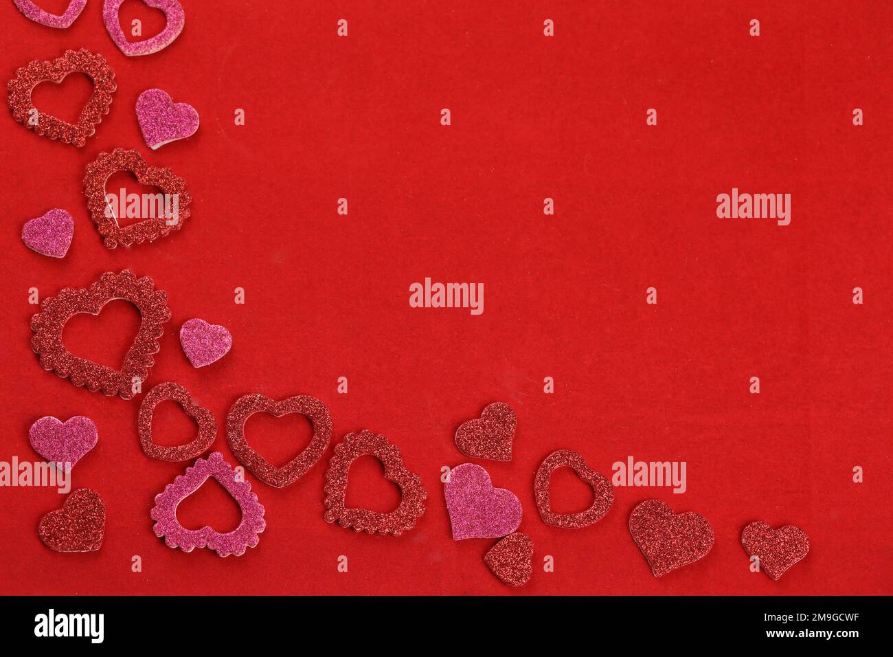 cuori rossi su sfondo rosso con spazio per il testo Foto Stock