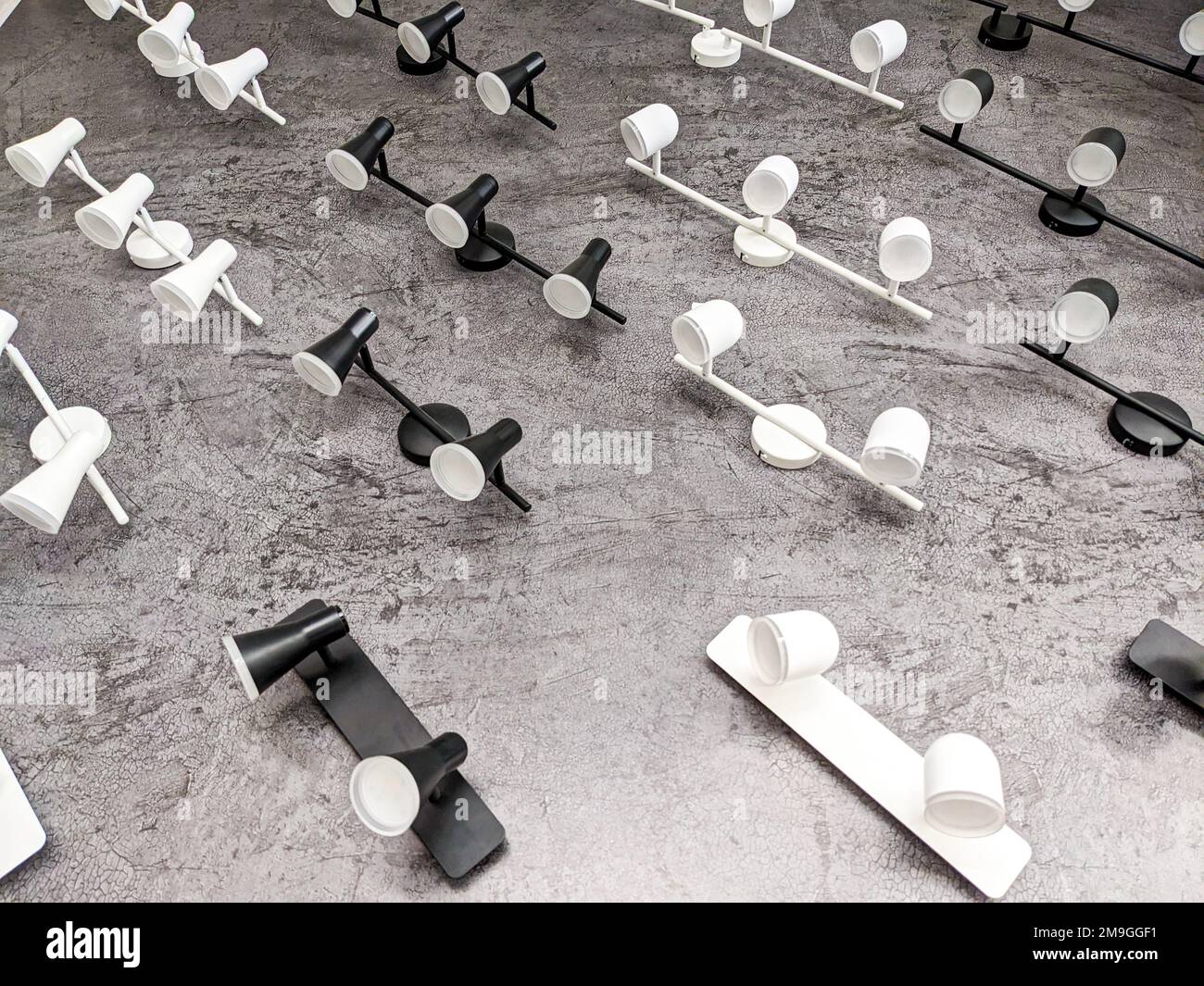 Molte lampade bianche e nere sulla parete. Articoli elettrici, lampadari, negozio di luci elettriche. Foto Stock