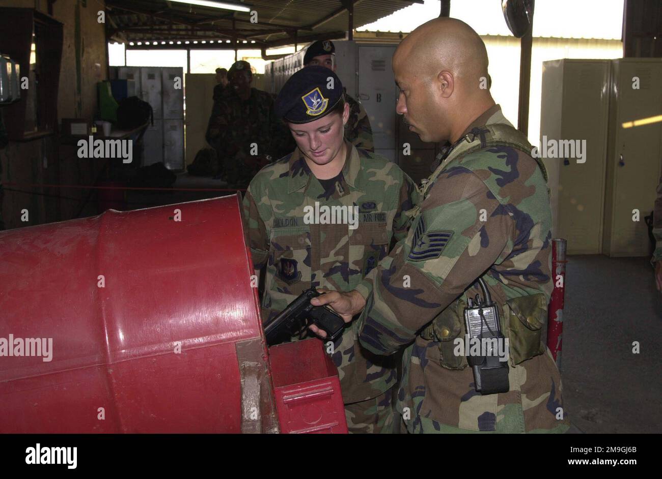 AIRMAN First Class Kathleen Sheldon, USAF, (a sinistra), assiste il tecnico Sergente Jose Garcia, 39th Security Forces Squadron, nello sgombero della sua pistola 9mm M9 prima del servizio, dopo Incirlik Air base, Turchia. La base ha implementato nuove posizioni di sicurezza a seguito di attacchi terroristici apparenti alle Torri Gemelle dei World Trade Center a New York e al Pentagono, quando i dirottatori volavano deliberatamente aerei di linea civili negli edifici, la mattina del 11 settembre 2001. Base: Incirlik Air base, Adana Paese: Turchia (TUR) scena comando principale mostrato: USAFE Foto Stock
