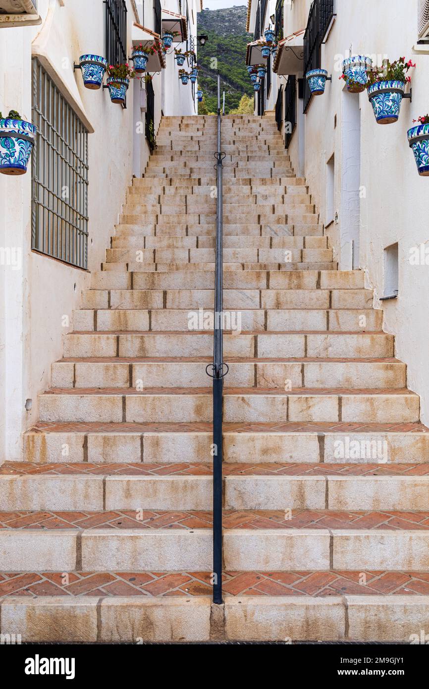 Passaggio con scale decorate con fiori. Mijas Pueblo, tipico villaggio collinare bianco (Pueblo Blanco). Costa del Sol, Andalusia, Spagna. Foto Stock