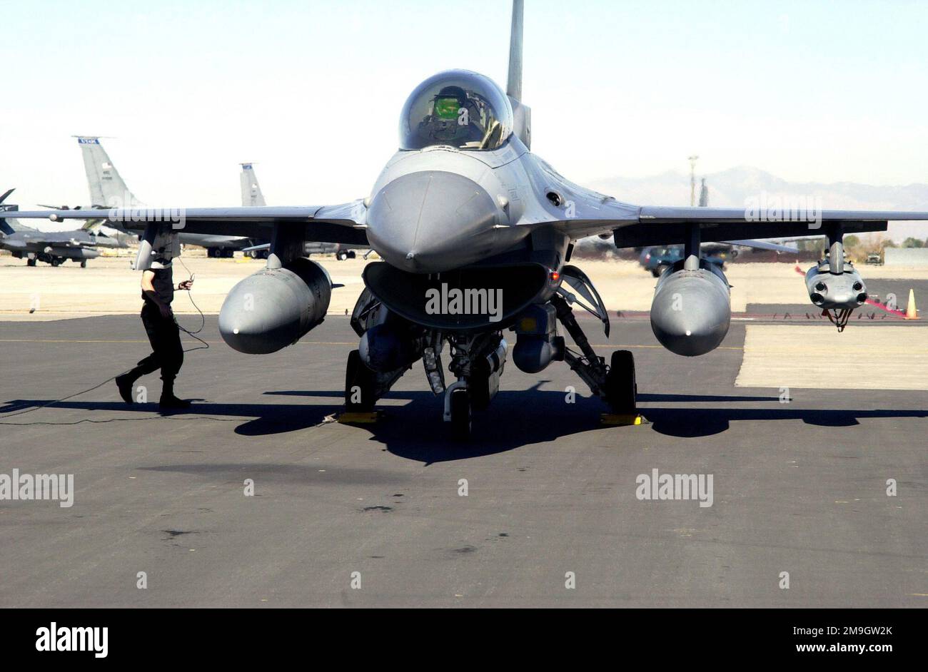 Un aereo da combattimento Hill Air Force base 421st Squadron AIRMAN si prepara a rimuovere le zeppe su un F-16D Fighting Falcon. Il F-16D, con due carri armati da 600 galloni e una bomba SSU-20, è stato parcheggiato sulla linea di volo della Guardia Nazionale dell'aria dello Utah durante la notte ed è ora in partenza per una missione di addestramento. La rampa ANG dello Utah ospita regolarmente aerei transitori. Base: Salt Lake City Stato: Utah (UT) Paese: Stati Uniti d'America (USA) Scene Major Command mostrato: ANG Foto Stock