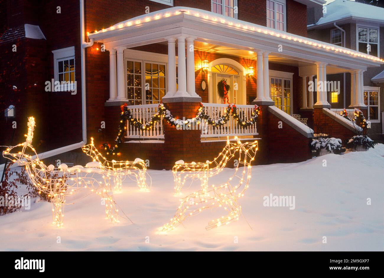 Esterno della casa la sera d'inverno con decorazioni natalizie Foto Stock