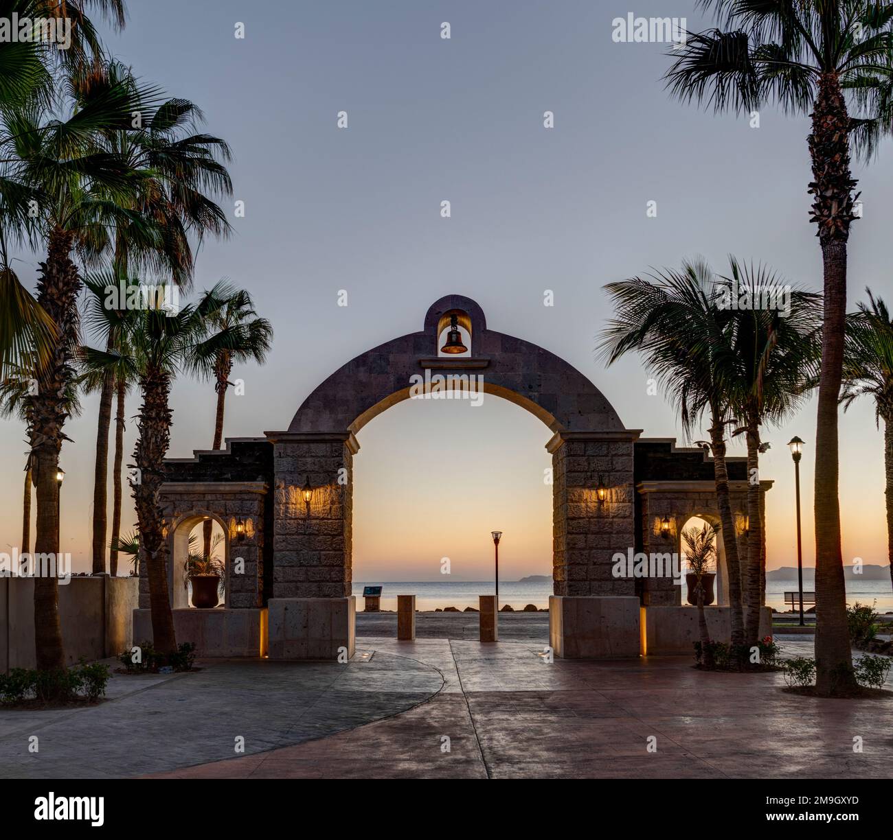 Porta ad arco e palme in riva al mare al tramonto, Loreto, Baja California sur, Messico Foto Stock