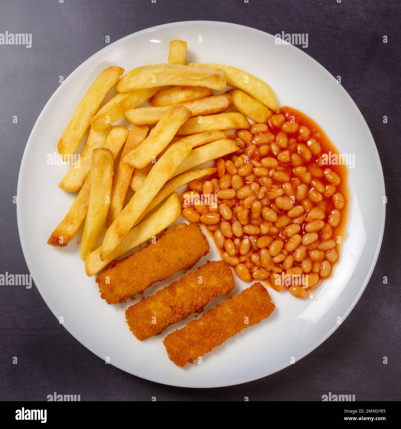 Fish barrette, patatine fritte e fagioli cotti sul piatto dall'alto Foto Stock