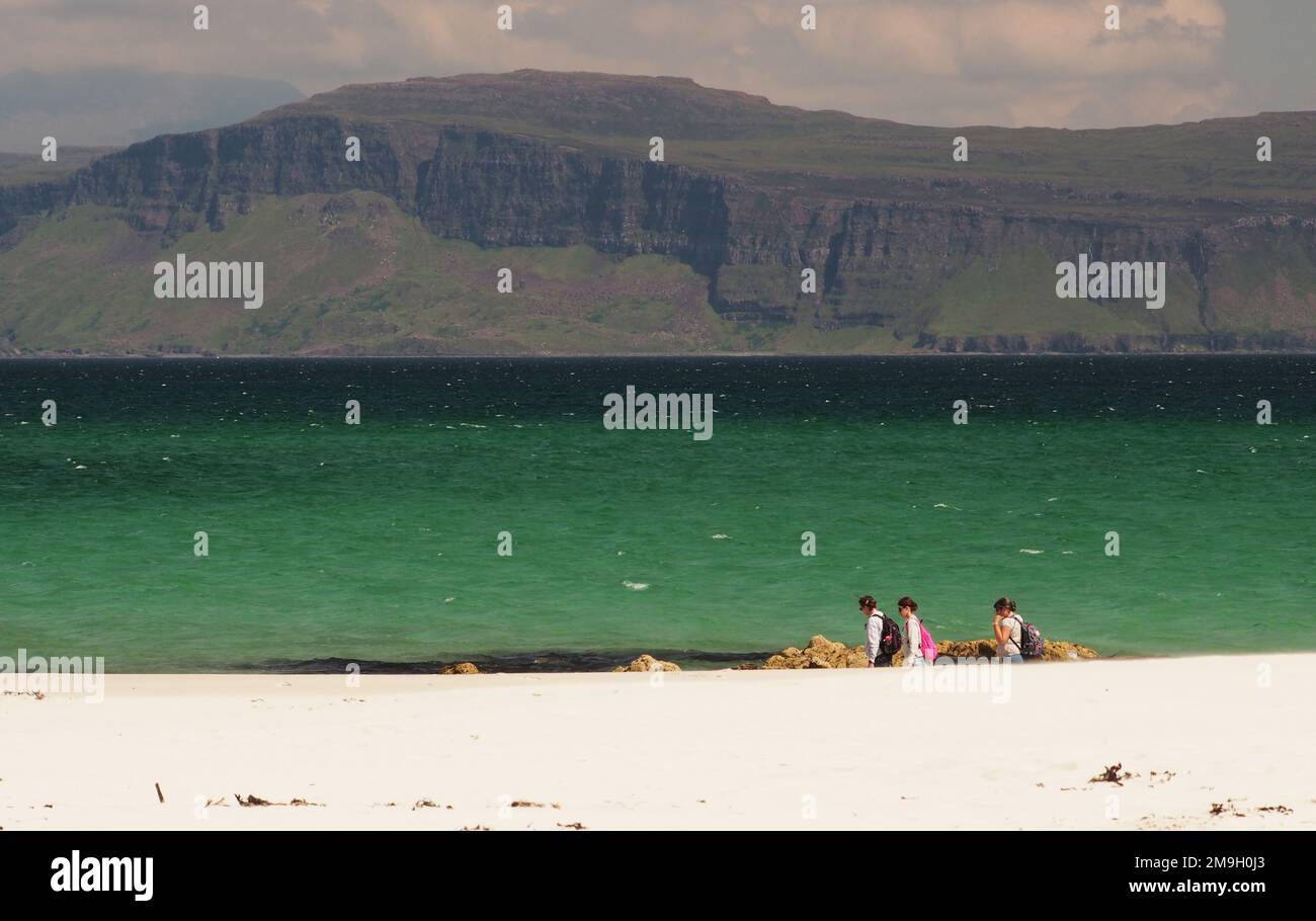 Tre giovani donne sul White Strand della spiaggia di Monk Iona, Scozia UK, che guarda sopra il Sound of Iona a Mull in un giorno di sole, d'estate Foto Stock